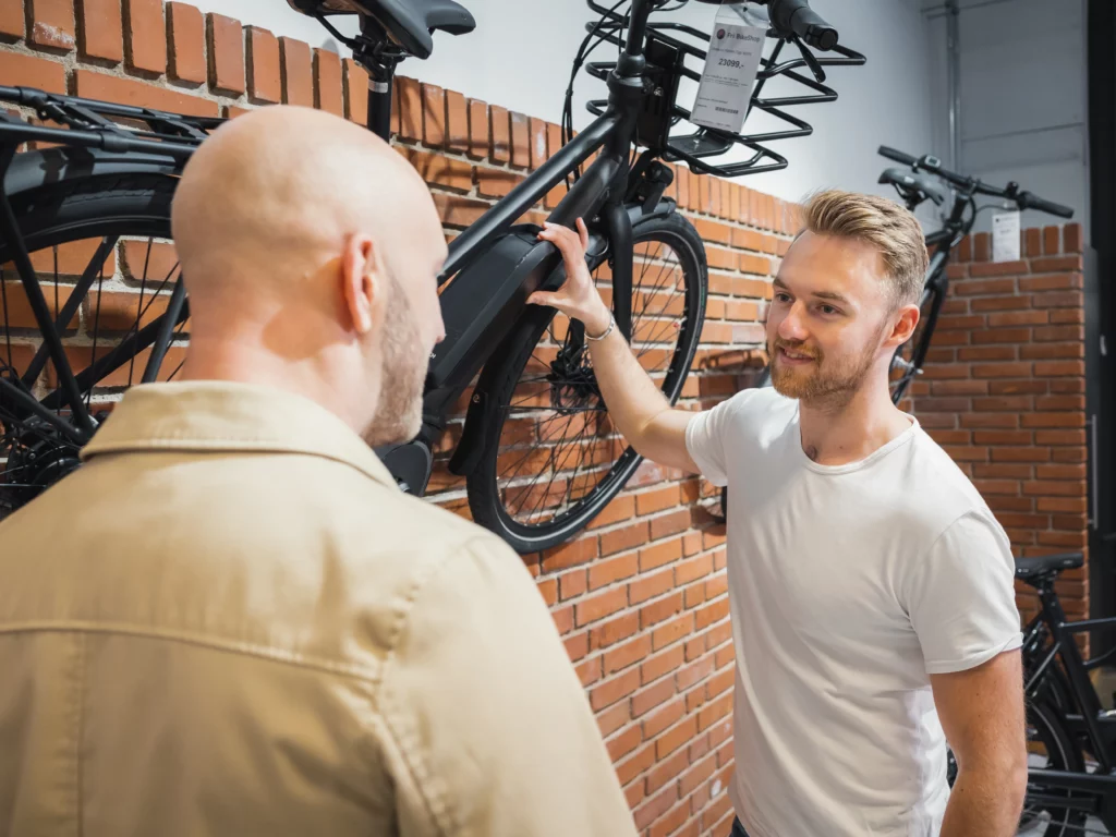 Cykelhandler viser cykel frem til kunde